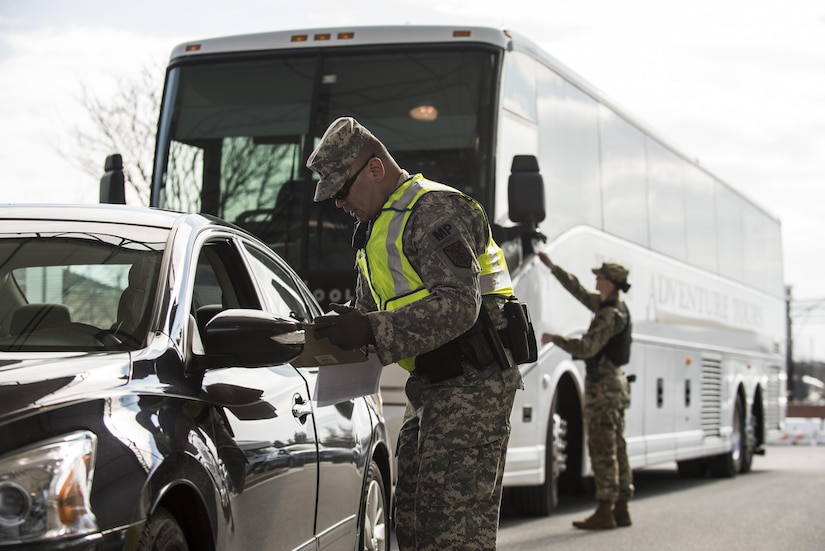 Sgt. Michael Villena (right), U.S. Army Reserve military police Soldier from Manassas Par, Va., with the 352nd MP Company, of the 200th MP Command, checks a driver's paperwork at one of the entry gates to Joint Base Myer-Henderson Hall, as part of a partnership training program with active duty Soldiers from the 289th MP Co., belonging to the 3rd U.S. Infantry Regiment (The Old Guard), to provide law and order, security and patrol support at various active duty installations in the Military District of Washington, D.C., Feb. 17. This partnership pilot program began in early February, placing Army Reserve Soldiers on active duty orders for three weeks while working at Joint Base Myer-Henderson Hall, Fort Lesley J. McNair and the Arlington National Cemetery. Soldiers will also support the Military District of Washington with additional duty days throughout the year. (U.S. Army photo by Master Sgt. Michel Sauret)