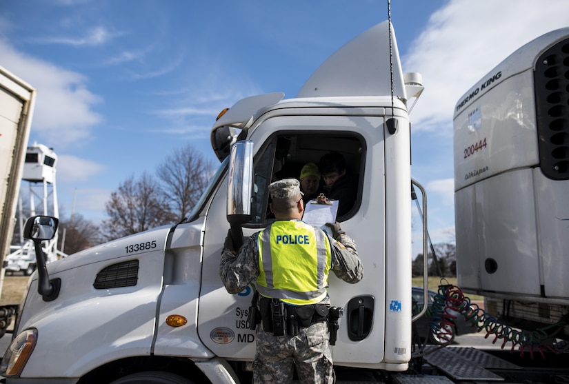 Sgt. Michael Villena (right), U.S. Army Reserve military police Soldier from Manassas Par, Va., with the 352nd MP Company, of the 200th MP Command, checks a driver's paperwork at one of the entry gates to Joint Base Myer-Henderson Hall, as part of a partnership training program with active duty Soldiers from the 289th MP Co., belonging to the 3rd U.S. Infantry Regiment (The Old Guard), to provide law and order, security and patrol support at various active duty installations in the Military District of Washington, D.C., Feb. 17. This partnership pilot program began in early February, placing Army Reserve Soldiers on active duty orders for three weeks while working at Joint Base Myer-Henderson Hall, Fort Lesley J. McNair and the Arlington National Cemetery. Soldiers will also support the Military District of Washington with additional duty days throughout the year. (U.S. Army photo by Master Sgt. Michel Sauret)