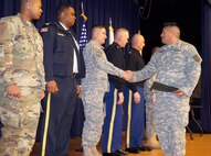 U.S. Army Lt. Col. Macedonio R. Molina, director of Emergency Services and provost marshal for Joint Base Myer-Henderson Hall, center left, shakes hands with the newest U.S. Army Reserve military police from the 200th MP Command of Fort Meade, Md., on Feb. 10 at Joe Rosenthal Theater on the Henderson Hall portion of the joint base. Members of the 200th MP Command, following a two-week law enforcement training course, will boost JBM-HH’s law enforcement manpower and force protection posture for the first time since Sept. 11, 2001, according to JBM-HH Police Chief William Johnson (second from left). (Joint Base Myer-Henderson Hall PAO photo by Arthur Mondale)
