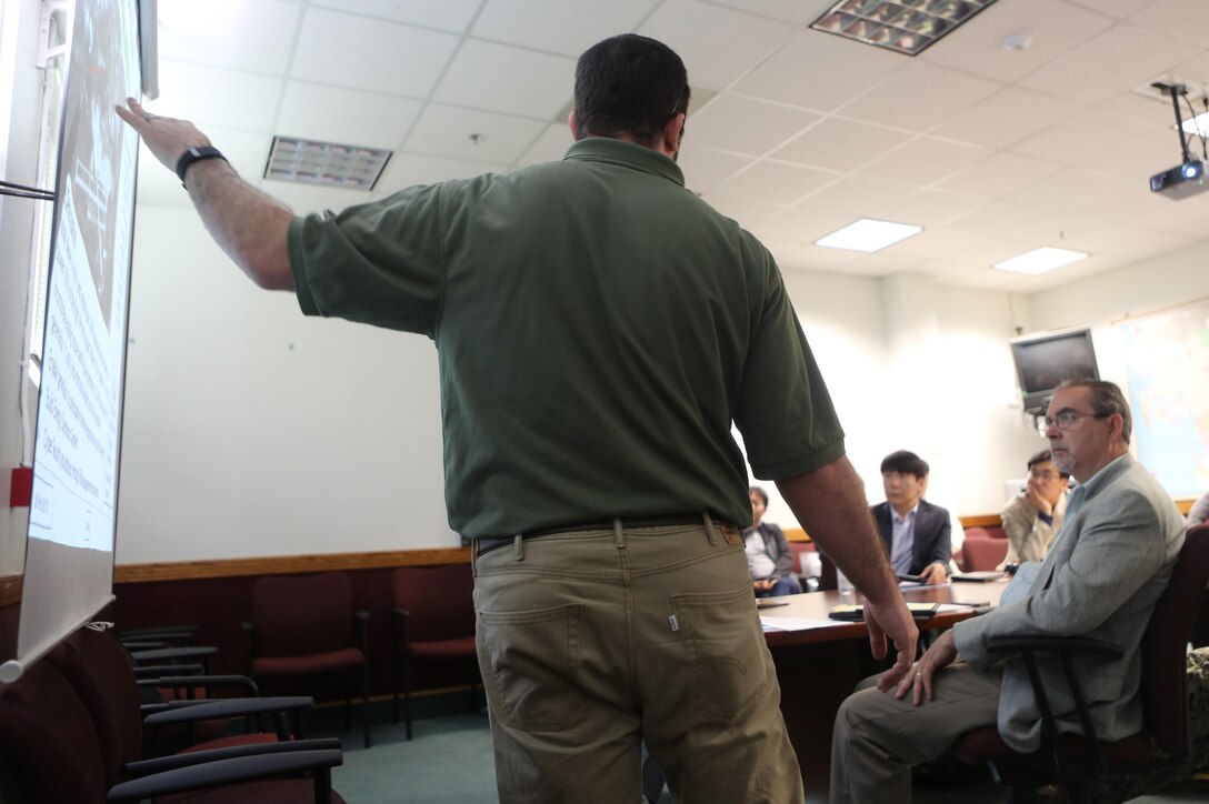 Mick Wasco, energy program manager for Marine Corps Air Station Miramar, Calif., informs a Korean delegation about air station energy-conservation projects during their visit aboard MCAS Miramar, Feb. 17. The delegation consisted of 14 South Korean citizens along with two American citizens. They visited different projects, such as a Primus Power battery, a liquid battery used for energy storage on the electric grid aboard the installation. (U.S. Marine Corps photo by Cpl. Kimberlyn Adams/Released)