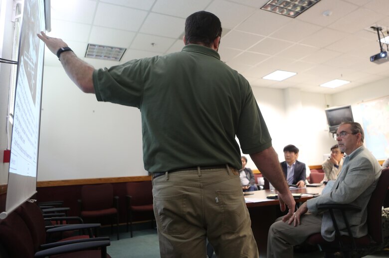 Mick Wasco, energy program manager for Marine Corps Air Station Miramar, Calif., informs a Korean delegation about air station energy-conservation projects during their visit aboard MCAS Miramar, Feb. 17. The delegation consisted of 14 South Korean citizens along with two American citizens. They visited different projects, such as a Primus Power battery, a liquid battery used for energy storage on the electric grid aboard the installation. (U.S. Marine Corps photo by Cpl. Kimberlyn Adams/Released)