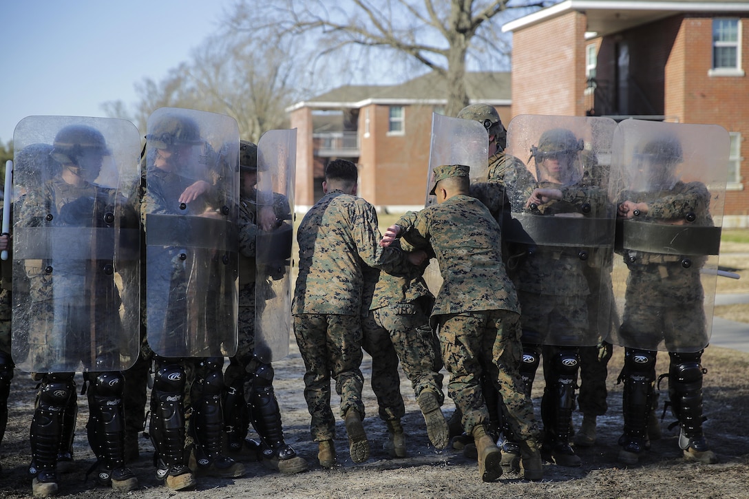 Marines with 2nd Law Enforcement Battalion practice an extraction team drill as part of a riot control exercise for the Evacuation Control Center team with Combat Logistics Battalion 2 on Camp Lejeune, N.C., Feb. 19, 2015. The ECC team will stand ready to extract U.S. personnel from a hostile situation in the AFRICOM area of responsibility during CLB-2’s upcoming deployment.  (U.S. Marine Corps photo taken by Cpl. Alexander Mitchell/released)