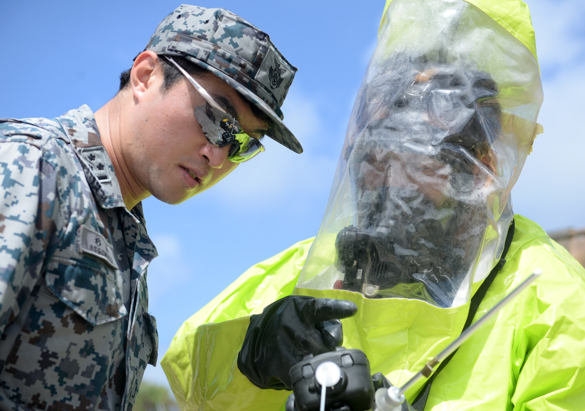 Japan Air Self-Defense Force Capt. Naoki Naoki, watches as JASDF Staff Sgt. Kazuma Noshita, a fire fighter, examines readings of contamination from a chemical, biological, radiological and nuclear detector during Partner Nation Silver Flag, Feb. 16, 2016, at Andersen Air Force Base, Guam. The exercise is a small part of the first multilateral Silver Flag Exercise, a U.S. Pacific Command multilateral Theater Security Cooperation Program subject matter expert exchange event designed to build partnerships and promote interoperability through the equitable exchange of civil engineer related information. (U.S. Air Force photo by Senior Airman Joshua Smoot/Released)