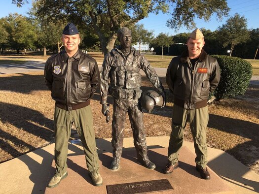 Justin Medlen (Air force) and Jeremy Medlen (Navy), pose next to a pilot statue Feb 13, 2016, in Pensacola, Florida. Jeremy had just graduated from pilot training and received his pilot wings the day before. Jeremy’s twin brother Justin is also a military pilot.  (Courtesy photo)