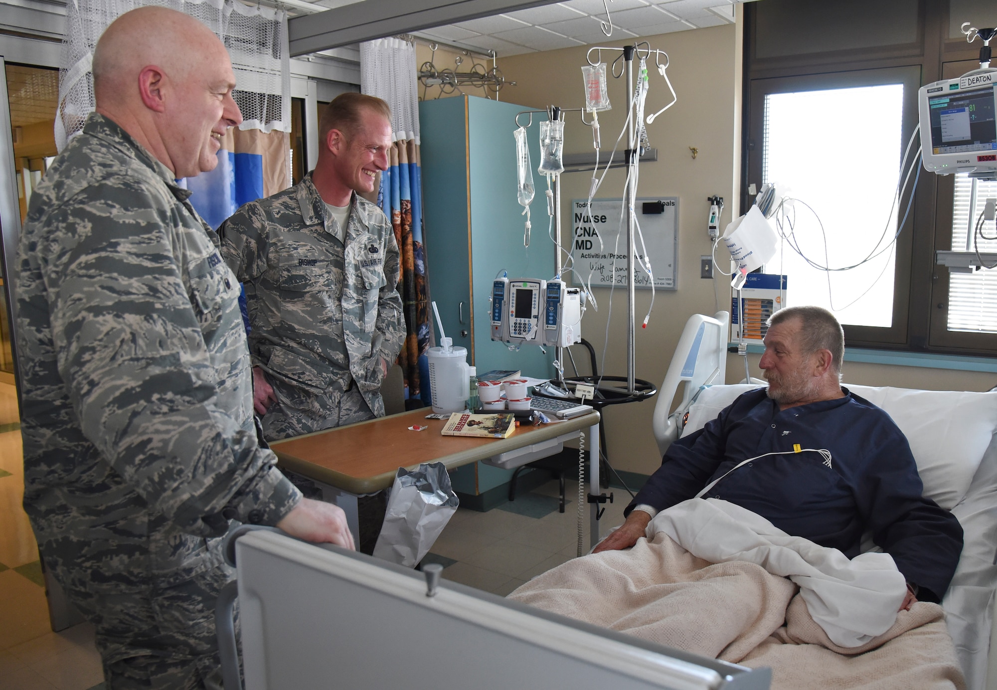 Col. Mark Fischer, 141st Air Refueling Wing vice commander, and Chief Master Sgt. David Bishop, 141st ARW command chief, visit with Gaylin Deaton, retired Army ranger, during National Salute to Veteran Patients Week Feb. 18, 2016, at Mann-Grandstaff VA Medical Center in Spokane, Wash. The leadership furthered the impact of Total Force Integration by meeting with numerous veteran patients, hearing their stories and handing out pins to commemorate the week. (U.S. Air Force photo/Airman 1st Class Mackenzie Richardson)