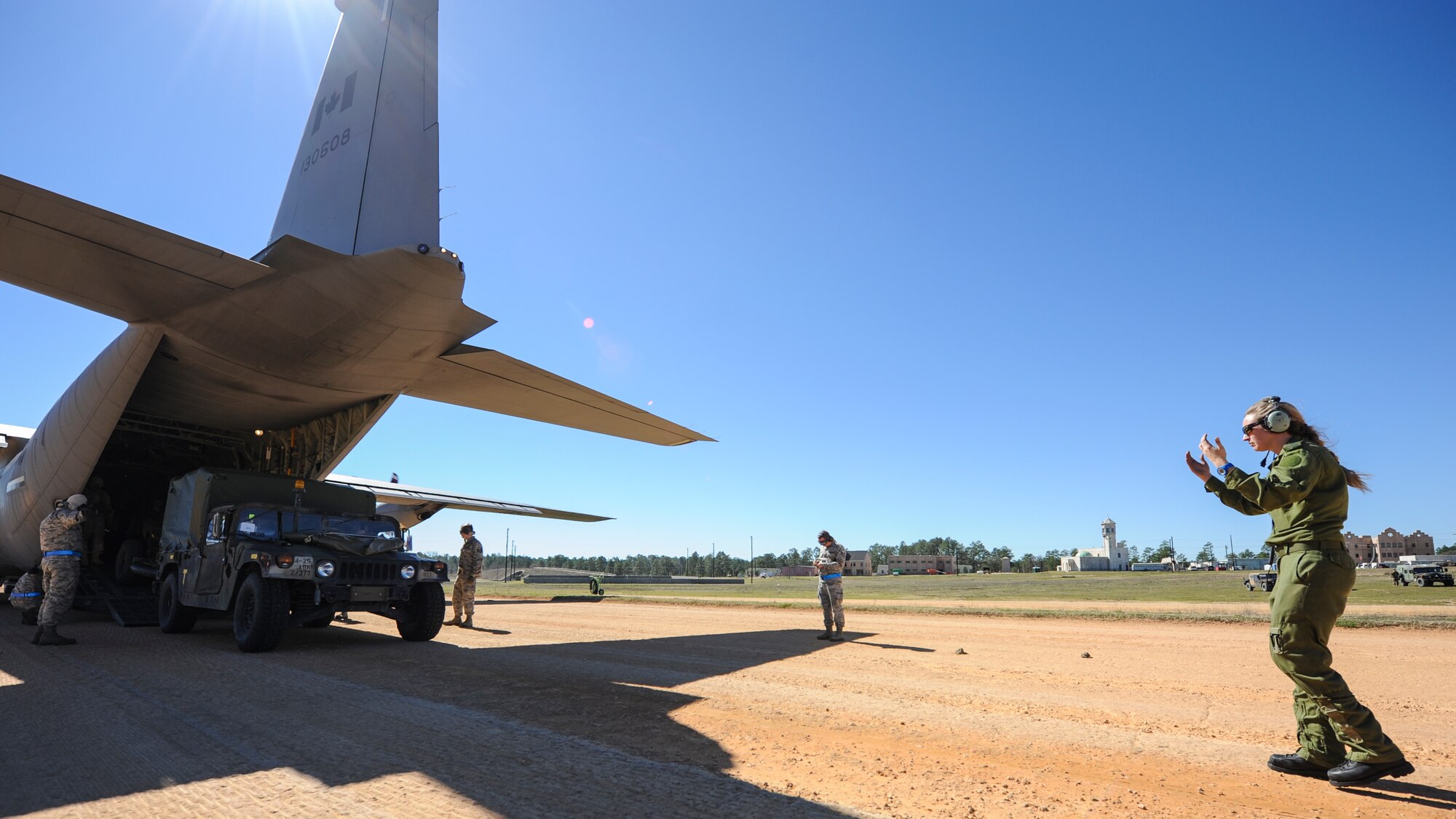 A Royal Canadian Air Force loadmaster directs a U.S. Army Humvee off of a RCAF C-130J during GREEN FLAG 16-04 Feb. 17, 2016, at the Geronimo Landing Zone on Fort Polk, La. Canadian airmen worked alongside U.S. Airmen and soldiers to improve Air Force strategic airlift in a simulated expeditionary environment. (U.S. Air Force photo/Senior Airman Harry Brexel) 