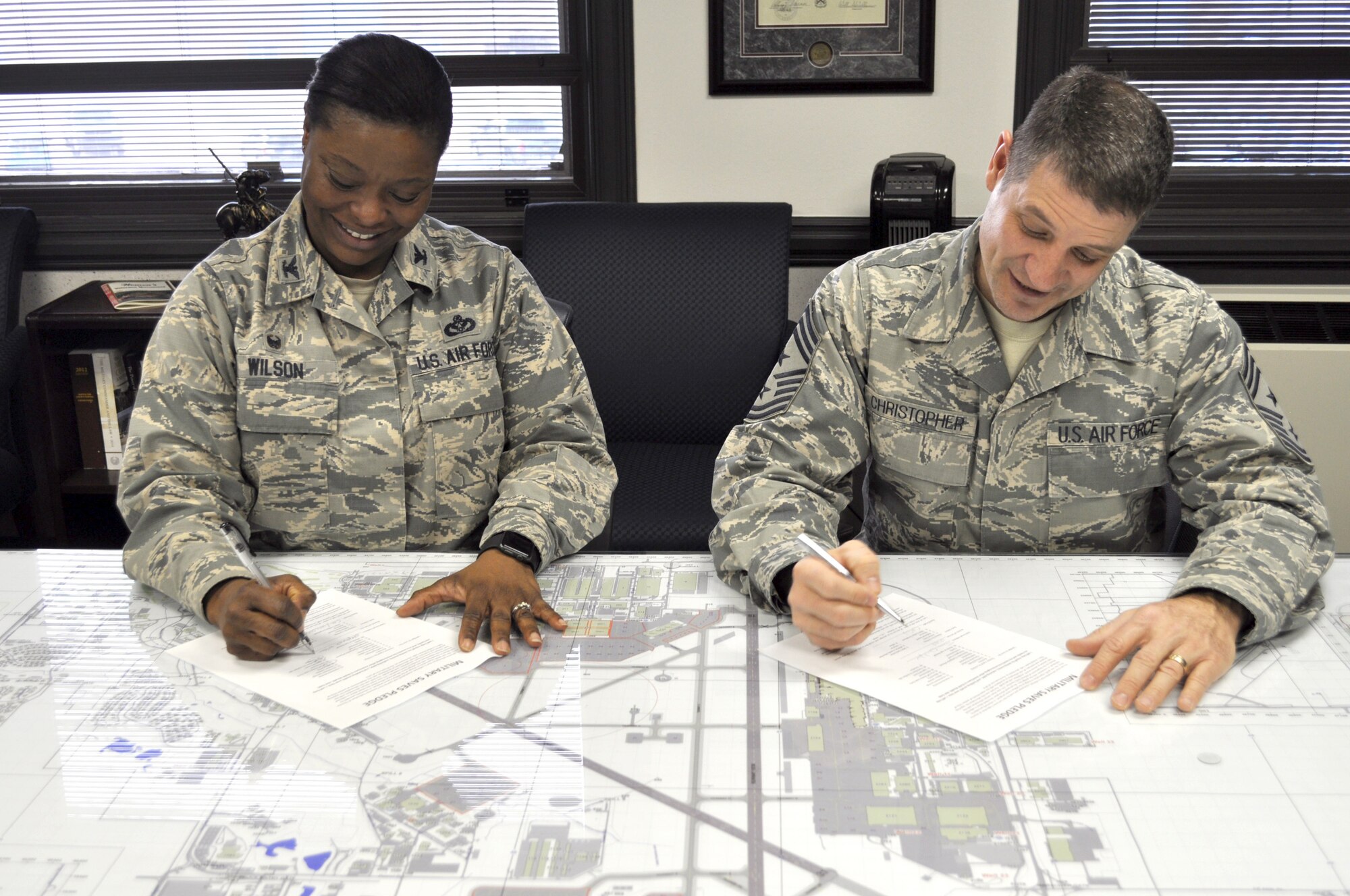 Col. Stephanie Wilson, 72nd Air Base Wing and Tinker installation commander, and 72nd ABW Command Chief Master Sgt. Thomas Christopher fill out their Military Saves Pledges. Military Saves Week runs from Feb. 22-26. (Air Force photo by Kimberly Woodruff/Released)