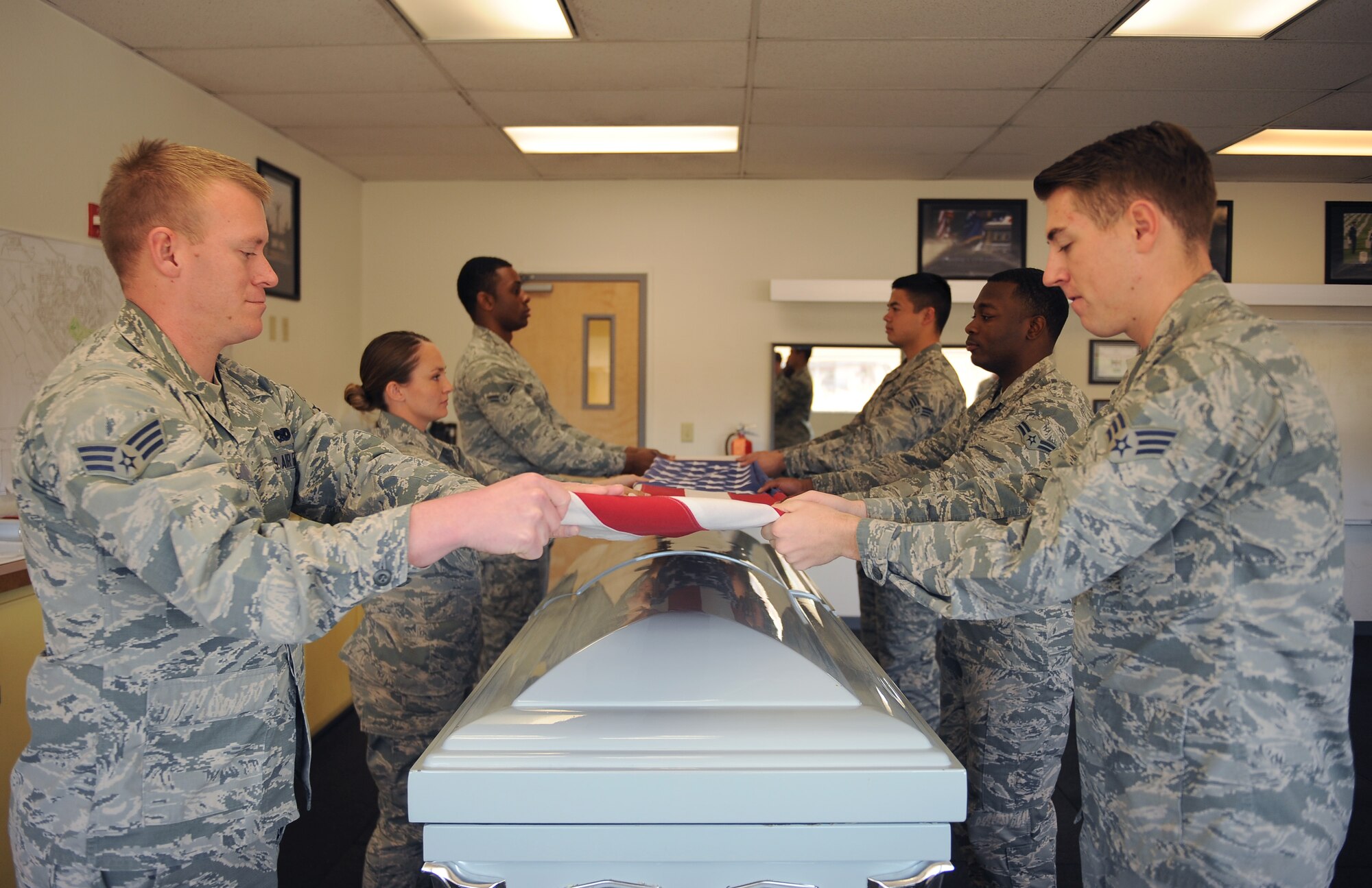 U.S. Airmen from the base honor guard practice a six-man flag folding sequence at Daivs-Monthan Air Force Base, Ariz., Feb 18, 2015. The honor guard’s mission is to provide military funeral honors for members of the Air Force and its predecessors. D-M honor guardsmen train seven to eight hours a day to sharpen the sequences they perform during details. (U.S. Air Force photo by Senior Airman Cheyenne A. Powers/ Released) 