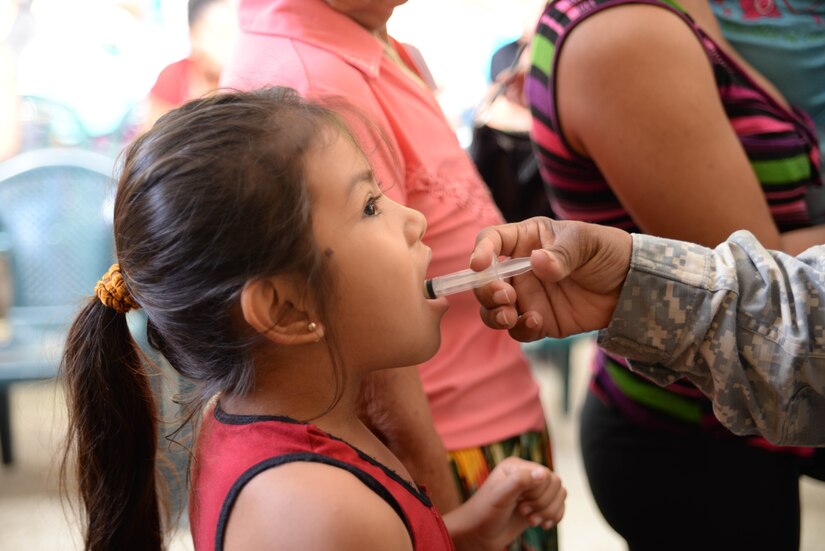 U.S. Army Capt. Marshon Ford, preventative medicine technician, gives a girl medicine during a medical readiness training exercise in the Cortes Department, Honduras, Feb. 18, 2016. MEDRETES like this provide military members with essential training in austere locations and builds local community relashions within the host country.  (U.S. Air Force Photo by Staff Sgt. Westin Warburton/Released)