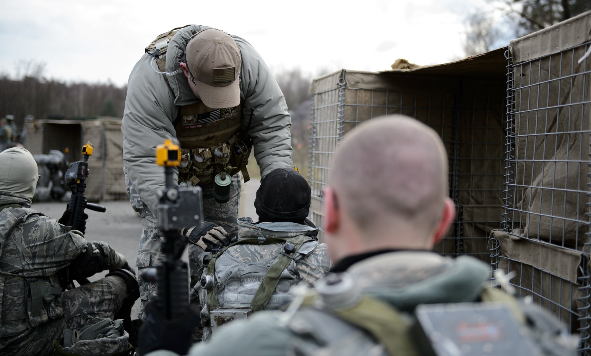 Staff Sg. John Burchfield, 1st Combat Communications Squadron instructor, “revives” Airmen who have been hit during the mock fire-fight at Ramstein Air Base, Germany, Feb. 12, 2016. The 1st CBCS uses lasers to determine when an Airman has been hit by opposing forces in order to make the training more realistic. (U.S. Air Force photo/Staff Sgt. Armando A. Schwier-Morales)