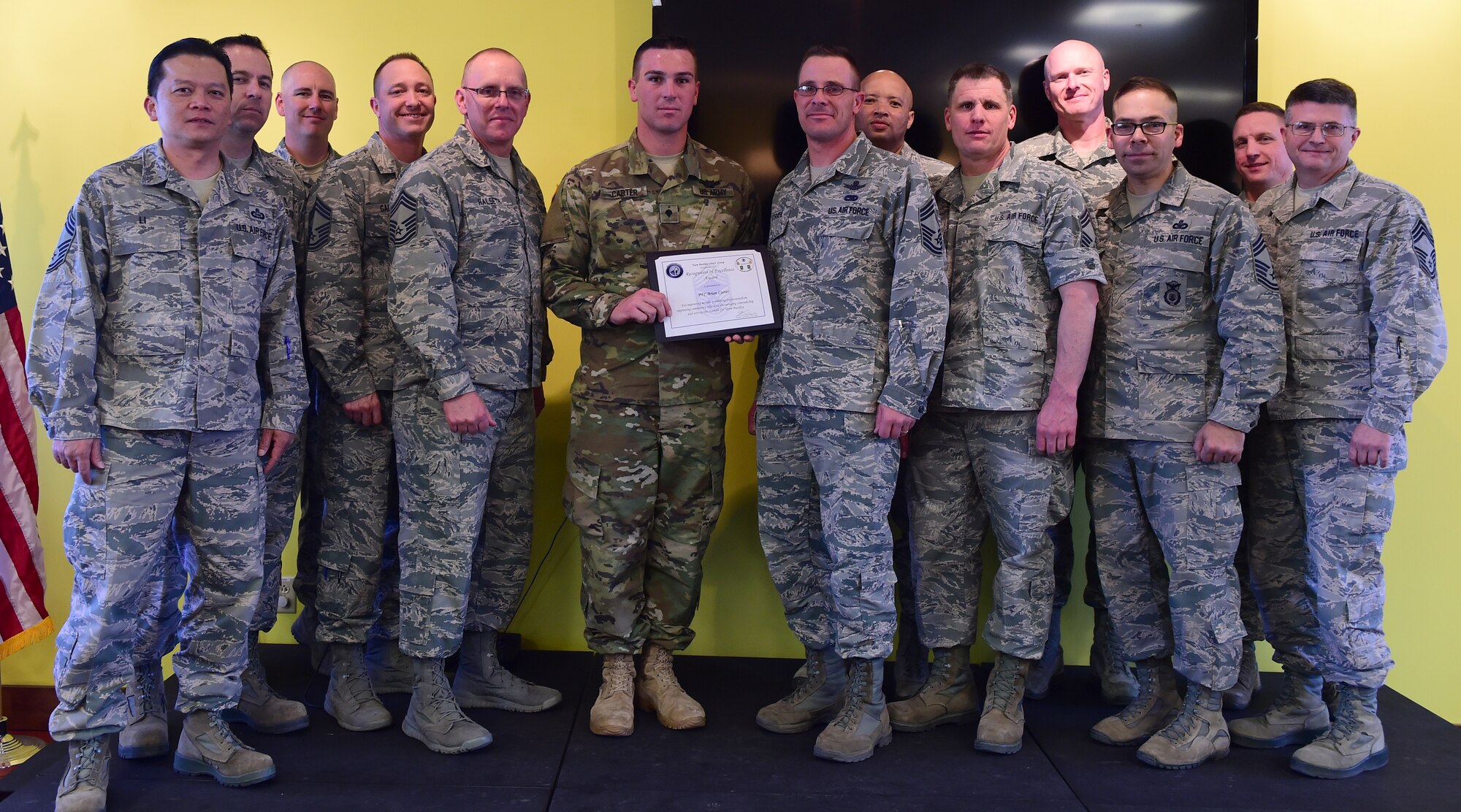 U.S. Army Spc. Brian Carter, 743d Military Intelligence Battalion analyst, stands with the Team Buckley Chief’s Group at the Panther Den Feb. 18, 2016, on Buckley Air Force Base, Colo. Carter exemplified excellence by taking on multiple leadership positions and providing fidelity on global weapon capability, which protected the nation’s warfighters in three areas of responsibilities. (U.S. Air Force photo by Senior Airman Racheal E. Watson/Released)