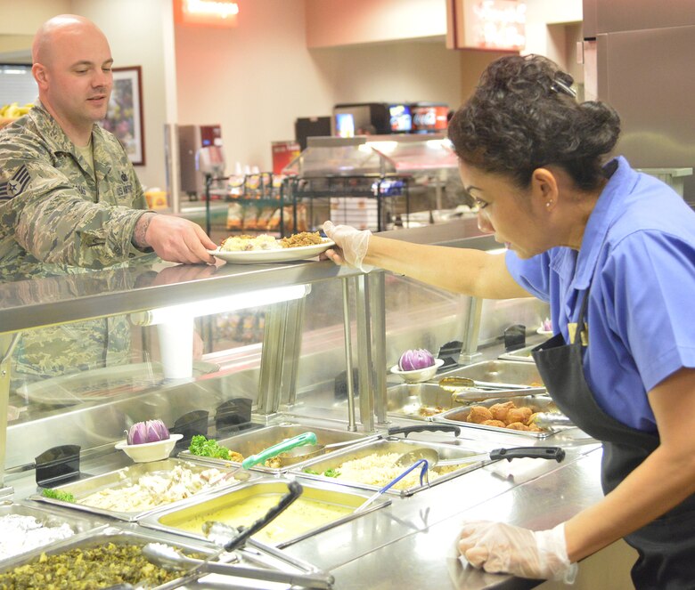 Sompit Amonchomchupong, Wynn Dinning Facility line server and cashier, dishes up lunch for Staff Sgt. Philip Arras with the 78th Security Forces Squadron. (U.S. Air Force photo by Ray Crayton)