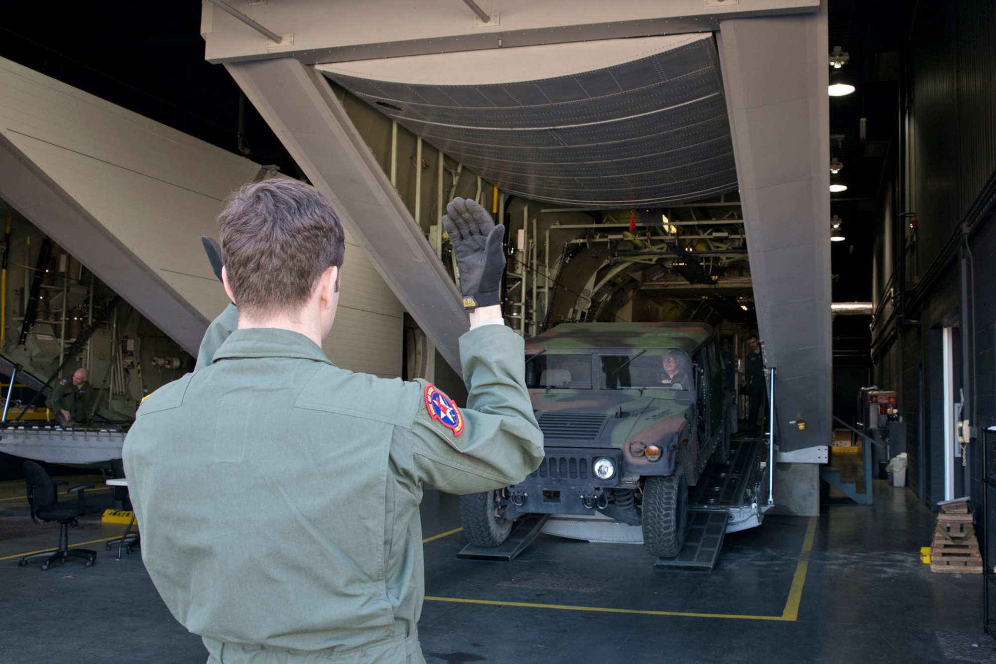 U.S. Air Force Airman 1st Class Benjamin McElwain, a loadmaster assigned to the 714th Training Squadron, directs the driver of a Humvee as he exits a C-130J fuselage trainer (FuT) at Little Rock Air Force Base, Ark., Feb. 16, 2016. Airmen from the 913th Airlift Group are transitioning from the C-130H Hercules to the C-130J Super Hercules, and aircrew personnel from the group use the FuT for retraining and certification on the new airframe. (U.S. Air Force photo by Master Sgt. Jeff Walston/Released)