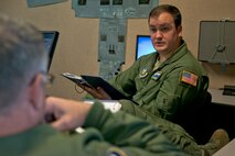 U.S. Air Force Reserve Tech. Sgt. Nick Crawford goes over checklists with Chief Master Sgt. Donald Tarrance, before climbing into a C-130 simulator at Little Rock Air Force Base, Ark., Dec. 2, 2015. Both Airmen are loadmasters assigned to the 327th Airlift Squadron, 913th Airlift Group, at Little Rock AFB, and are in training as part of the group’s transition from the “H” model to the “J” model. (U.S. Air Force photo by Master Sgt. Jeff Walston/Released)