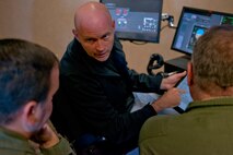 Jimmy McKenzie, a loadmaster instructor, discusses fuel tank levels with two 913th Airlift Group students at a U.S. Air Force C-130 Aircrew Training System schoolhouse at Little Rock Air Force Base, Ark., Dec. 2, 2015. The 913 AG is transitioning from the C-130H Hercules to the C-130J Super Hercules. Aircrew and maintenance personnel from the group are in the process, of training and gaining certification on the new airframe. (U.S. Air Force photo by Master Sgt. Jeff Walston/Released)
