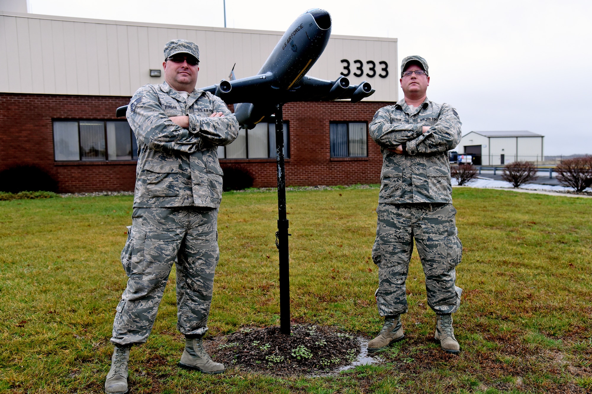 Staff Sgts. Murray Burgen, left, and Shaun Strain, both with the 108th Maintenance Group, pose in front of a KC-135E Stratotanker model in front of hangar 33-33. The aircraft structural maintenance craftmen worked on updating and remodeling the fiber-glassed display. (U.S. Air National Guard photo by Tech. Sgt. Armando Vasquez/Released)  
