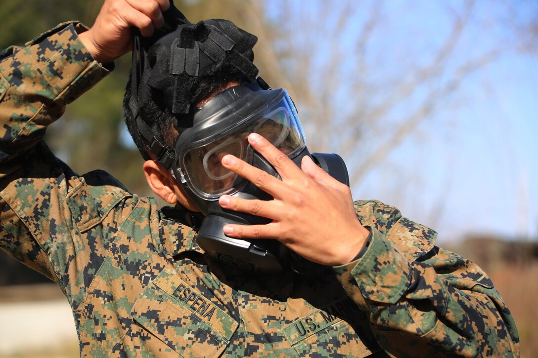 Cpl. Justin D. Espena removes his M50 Joint Service General Purpose Gas Mask after exciting the gas chamber at Marine Corps Air Station Cherry Point, N.C., Feb. 10, 2016. Marines with Marine Aviation Logistics Squadron 14 faced CS gas in the gas chamber as part of their qualification to familiarize themselves with the equipment and skills if faced with a biochemical attack. Marines of every military occupational specialty must be proficient with the equipment as it is part of every Marines’ basic skills. Espena is an aircraft maintenance  support equip hydraulic, pneumatic, structure mechanic with MALS-14. (U.S. Marine Corps photo by Cpl. N.W. Huertas/Released)