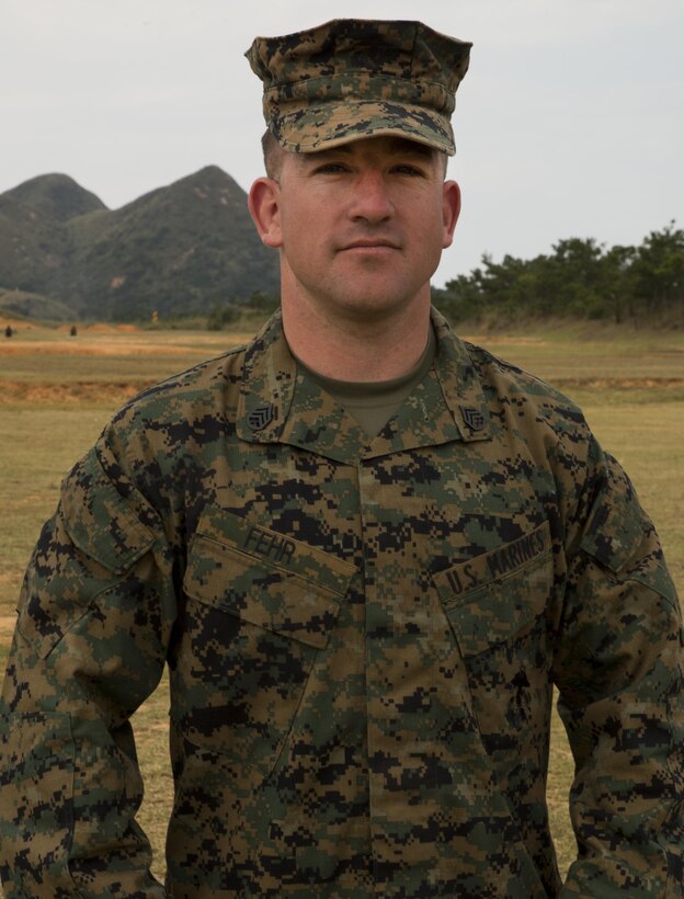 Staff Sgt. James M. Fehr, a San Manuel, Arizona native, poses for a photo on range 18 aboard Camp Hansen, Okinawa, Japan. Fehr traveled to Okinawa from Quantico, Virginia to coach Marines participating in a three-gun shooting competition where Marines shot the M9 pistol, M1014 shotgun and the M16A4 service rifle. “Our goal is to make the Marines into better warfighters,” said Fehr. “Everyone benefits from going out and training in their weapon systems.” Fehr is a competitor, instructor and staff non-commissioned officer in charge of the U.S. the Marine Corps Combat Shooting Team. (U.S. Marine Corps Photo by Cpl. Brittany A. James/ Released)