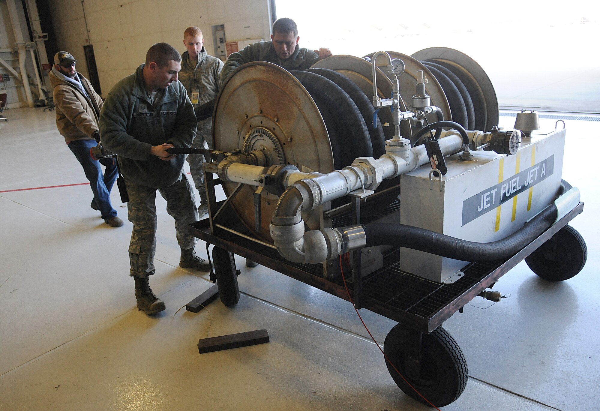U.S. Air Force Staff Sgt. Daniel Huffstetler, left, the 509th Civil Engineer Squadron (CES) water and fuels system maintenance supervisor, reels a fueling hose at Whiteman Air Force Base, Mo., Feb. 12, 2016. Alongside other fueling sections on base, the CES liquid fuels shop assists in the safe and timely defueling and refueling of Whiteman’s B-2 Spirit fleet. (U.S. Air Force photo by Airman 1st Class Michaela R. Slanchik)