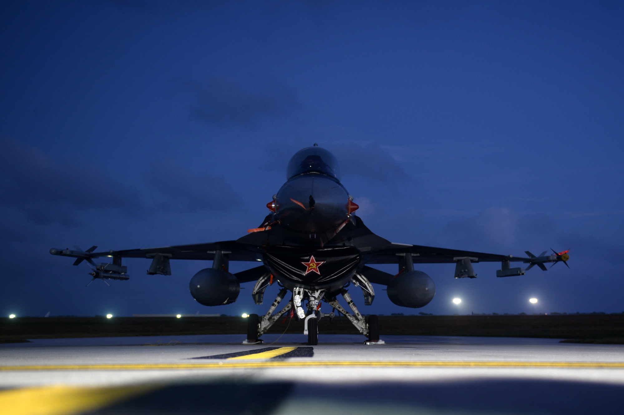 A F-16 Fighting Falcon sits on the flightline the morning of Feb. 20, as Airmen set up for the 2016 Pacific Partners Open House at Andersen Air Force Base, Guam. The event included multiple aircraft static displays, flyovers, ground demonstrations and live bands. (U.S. Air Force photo/Senior Airman Joshua Smoot) 