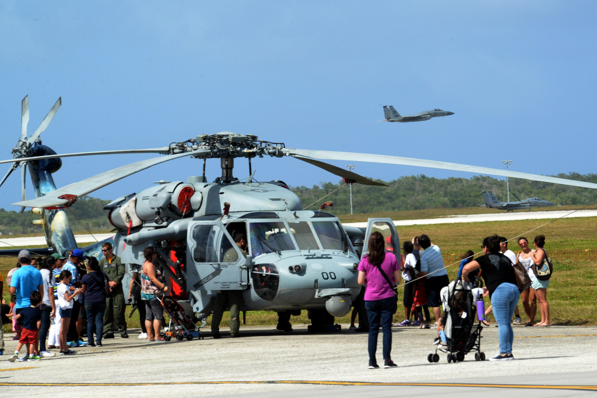 A F-15 Eagle soars past a crowd of people admiring a Helo Feb. 20 during the 2016 Pacific Air Partners Open House at Andersen Air Force Base, Guam. The open house aims to enhance public awareness of the military's mission, equipment, facilities and personnel and to promote positive community relations.
(U.S. Air Force Photo/Airman 1st Class Alexa Ann Henderson)
