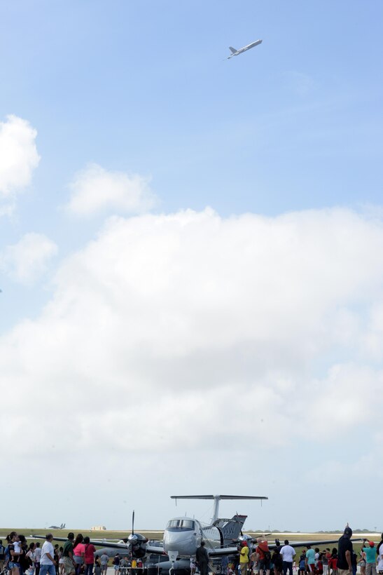 Spectators watch a B-52 Stratofortress maneuver in the air Feb. 20 during the 2016 Pacific Air Partners Open House at Andersen Air Force Base, Guam.  The largest community outreach event of the year, the open house aims to enhance public awareness of the U.S. military's mission, equipment, facilities and personnel and to promote positive community relations. (U.S. Air Force Photo/Airman 1st Class Alexa Ann Henderson)