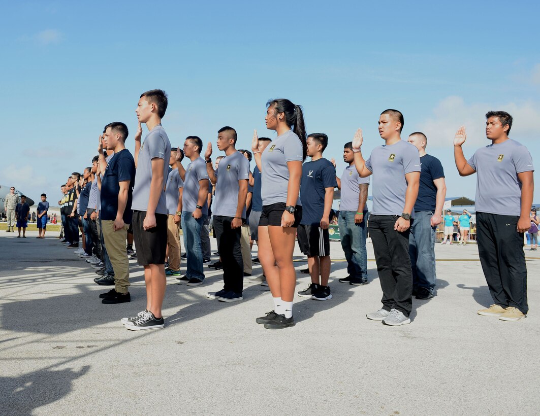 U.S. Air Force and Army recruits raise their right hand at an enlistment ceremony Feb. 20 during the 2016 Pacific Air Partners Open House at Andersen Air Force Base, Guam. Brig. Gen. Andrew Toth, 36th Wing commander, swore in more than 30 recruits into the U.S. Air Force, Army and Air National Guard. (U.S. Air Force photo/Airman 1st Class Arielle Vasquez)