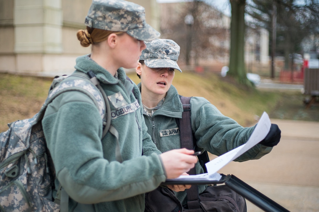 Army Spc. Amy Carle, a student at the Defense Information School on Fort Meade, Md., and a platoon guide at the U.S. Army Signal School Detachment Student Company on post, helps a fellow soldier, Pfc. Lauren Ogburn, on Feb. 17, 2016, before a morning formation. Carle, who works for Google at the company’s headquarters in Mountain View, California, joined the California National Guard in 2014 with a desire to use her professional skills to serve the country.