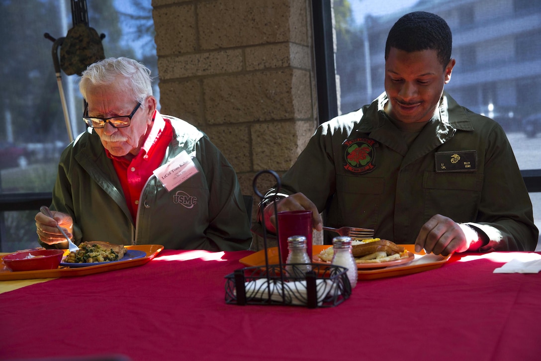 Tom Kalus, left, a Battle of Iwo Jima veteran, eats lunch with Marine Corps Cpl. Joel Riley during a tour of Marine Corps Air Station Miramar, Calif., Feb. 19, 2016. Kalus, other Iwo Jima veterans and their families visited the air station to commemorate the 71st anniversary of the Battle of Iwo Jima. Riley is an airframe mechanic assigned to Marine Medium Tiltrotor Squadron 363. Marine Corps photo by Sgt. Brian Marion