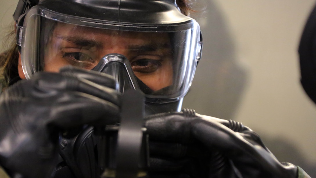 A Marine attaches a canteen to her M50 Joint Service General Purpose Mask during gas chamber training at Marine Corps Air Station Cherry Point, N.C., Feb. 10, 2016. Marines with Marine Aviation Logistics Squadron 14 faced the CS gas as part of their qualification to familiarize themselves with the equipment and skills if faced with a biochemical attack. Marines of every military occupational specialty must be proficient with the equipment as it is part of every Marines’ basic skills.