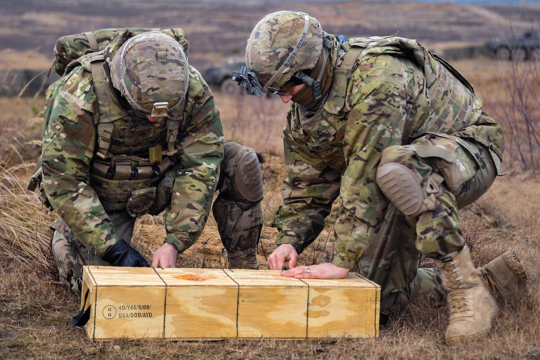 Army Pfcs. Austin Adame, left, and Joseph Huling open a box of simulation rounds for a M224 60 mm mortar system at the Drawsko Pomorskie training area, Poland, Feb. 10, 2016. Adame and Huling are assigned to the 3rd Squadron, 2d Cavalry Regiment. Army photo by Markus Rauchenberger