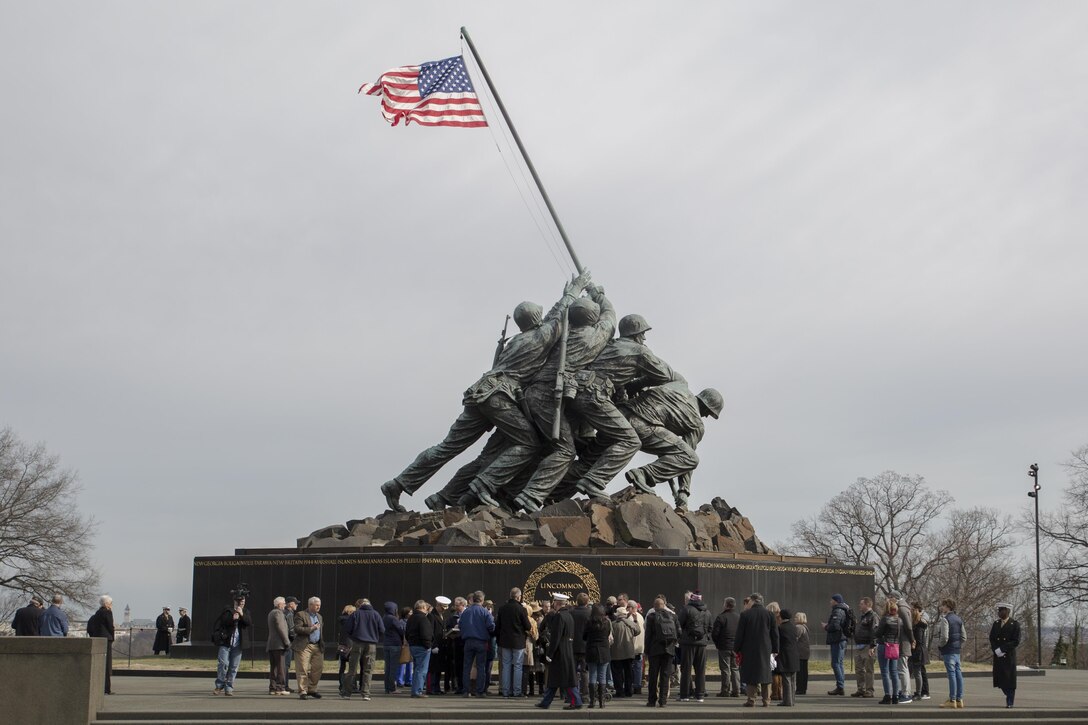 A group of WWII veterans, Marines, and civilians participate in a wreath laying ceremony at the Marine Corps War Memorial, Arlington, Va., Feb. 19, 2016. Earlier that morning, a memorial service commemorating the 71st anniversary of the landing on Iwo Jima took place at Crawford Hall, Marine Barracks Washington, D.C. Iwo survivors, family and friends traveled to the National Capitol Region to take part in the Iwo Jima Association of America’s 71st Anniversary, Reunion and Symposium. (Official Marine Corps photo by Cpl. Chi Nguyen/Released)