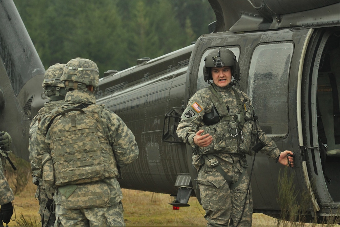An Army crew chief briefs soldiers on safely entering and exiting a UH-60 Black Hawk helicopter on Joint Base Lewis McChord, Wash., Feb. 10, 2016. The soldiers, assigned to the 16th Combat Aviation Brigade, learned to slingload communications equipment and air assault into an area to prepare for future missions. Army photo by Capt. Brian Harris