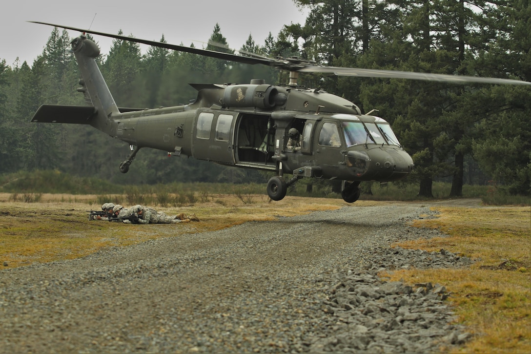 Soldiers provide security and maintain a defensive position while a UH-60 Black Hawk helicopter departs during air assault training on Joint Base Lewis-McChord, Wash., Feb. 10, 2016. Army photo by Capt. Brian Harris