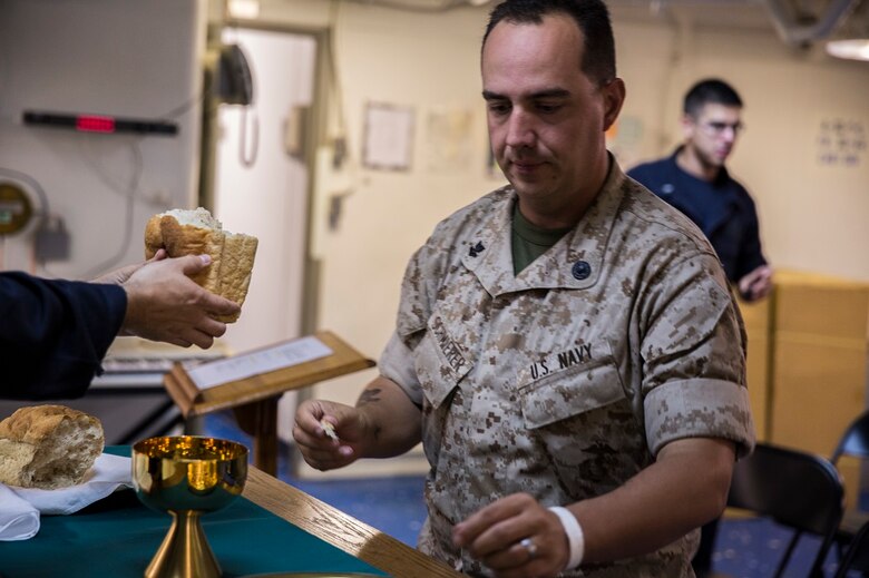 PACIFIC OCEAN (Feb. 14, 2016) – U.S. Navy Petty Officer 2nd Class Phillip Schmierer, a religious program specialist, completes the rite of Holy Communion during a church service aboard the USS New Orleans, At Sea, Feb. 14, 2016. Religious program specialists assist the chaplains in planning and conducting faith services and various programs. More than 4,500 Marines and Sailors with the 13th Marine Expeditionary Unit and Boxer Amphibious Ready Group are transiting the Pacific Ocean en route to the Pacific and Central command areas of operations.
