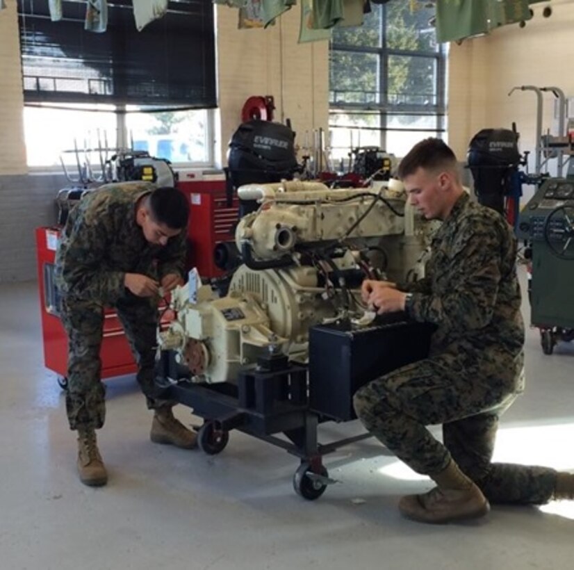 Sergeant Christian Cid and Lance Corporal David J. Illies, Marines from 1st Reconnaissance Battalion attached to Small Craft Mechanics course 2-16 (SCMC 2-16) at Marine Corps Engineer School; work together to remove the wiring harness from a Bridge Erection Boat (BEB) training engine during their BEB Electrical System practical application.

