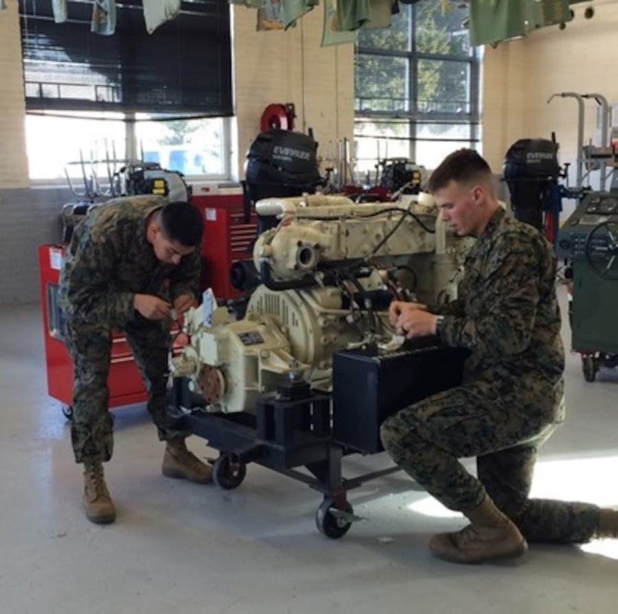 Sergeant Christian Cid and Lance Corporal David J. Illies, Marines from 1st Reconnaissance Battalion attached to Small Craft Mechanics course 2-16 (SCMC 2-16) at Marine Corps Engineer School; work together to remove the wiring harness from a Bridge Erection Boat (BEB) training engine during their BEB Electrical System practical application.

