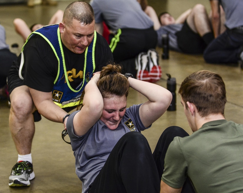 First Sgt. Anthony Childs, 1st Battalion, 518th Infantry Regiment, 98th Training Division (IET), helps a future Soldier complete a sit-up during push-up and sit-up drills at the Reserve Center in Asheville, N.C., Feb. 20, 2016. Childs helped coordinate the Future Soldiers program in which nearly 40 civillians from the area who have already or intend on enlisting into the Army showed up to recieve an introduction to basic Warrior tasks before they get to basic combat training. (U.S. Army photo by Sgt. 1st Class Brian Hamilton)