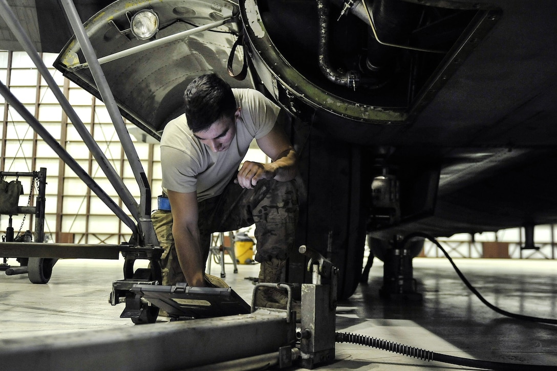 Air Force Senior Airman Dylan Shirley reviews the technical order before changing a tire on an EC-130 Compass Call on Bagram Airfield, Afghanistan, Feb. 10, 2016. Shirley is a crew chief assigned to the 455th Expeditionary Aircraft Maintenance Squadron. Air Force photo by Tech. Sgt. Nicholas Rau