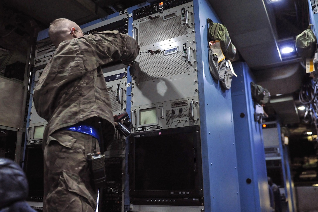 Air Force Senior Airman Brandon Clevinger removes a panel to inspect the systems inside an EC-130 Compass Call on Bagram Airfield, Afghanistan, Feb. 10, 2016. Clevinger is an electronic warfare systems journeyman assigned to the 455th Expeditionary Aircraft Maintenance Squadron. Air Force photo by Tech. Sgt. Nicholas Rau