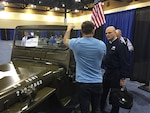 Defense Logistics Agency Aviation Commander Air Force Brig. Gen. Allan Day tours additive manufacturing displays Dec. 2, 2015 during the Defense Manufacturing Conference in Phoenix, Arizona. 