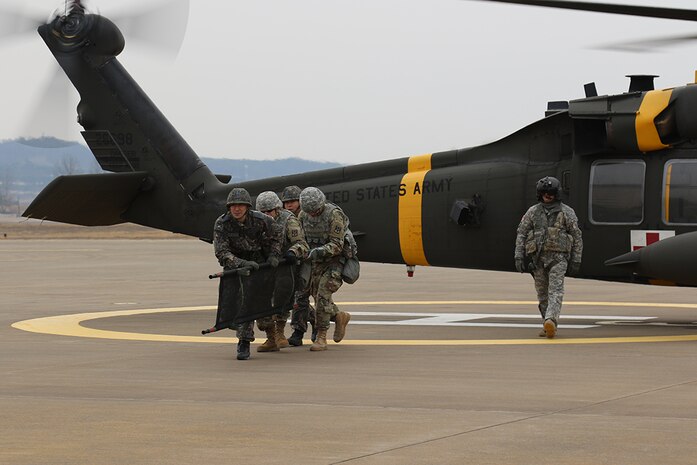 SUWON AIR BASE, South Korea (Feb. 18, 2016) - A medic team disengages the UH-60 Blackhawk where they just loaded a casualty during mass casualty training as part of the Headquarters and Headquarters Battery, 6th Air Defense Artillery Battalion, 52nd ADA Regiment, 35th ADA Brigade and Republic of Korea Air Force 10th Fighter Wing Combined Base Defense Exercise while flight crew medic Staff Sgt. Travis Holley evaluates their technique. 
