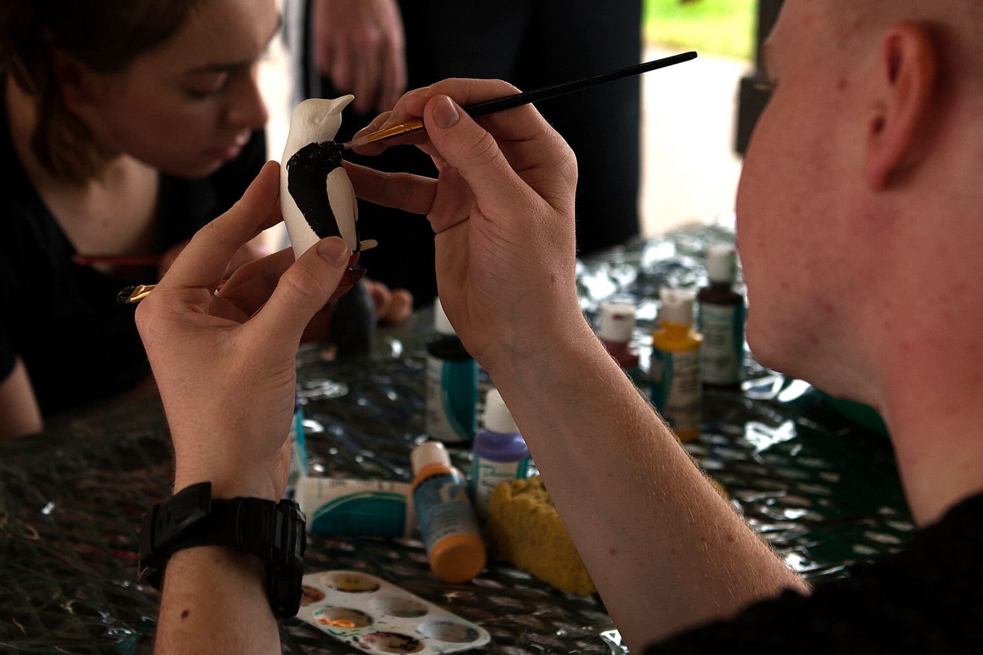 Goodfellow Air Force Base members paint ceramic figures during the Polar Bear Plunge at Goodfellow Recreation Camp, San Angelo, Texas, Feb. 22, 2016. The Arts and Crafts Center on base provided the ceramic figures and painting equipment for the event. (U.S. Air Force photo by Airman 1st Class Caelynn Ferguson/Released)