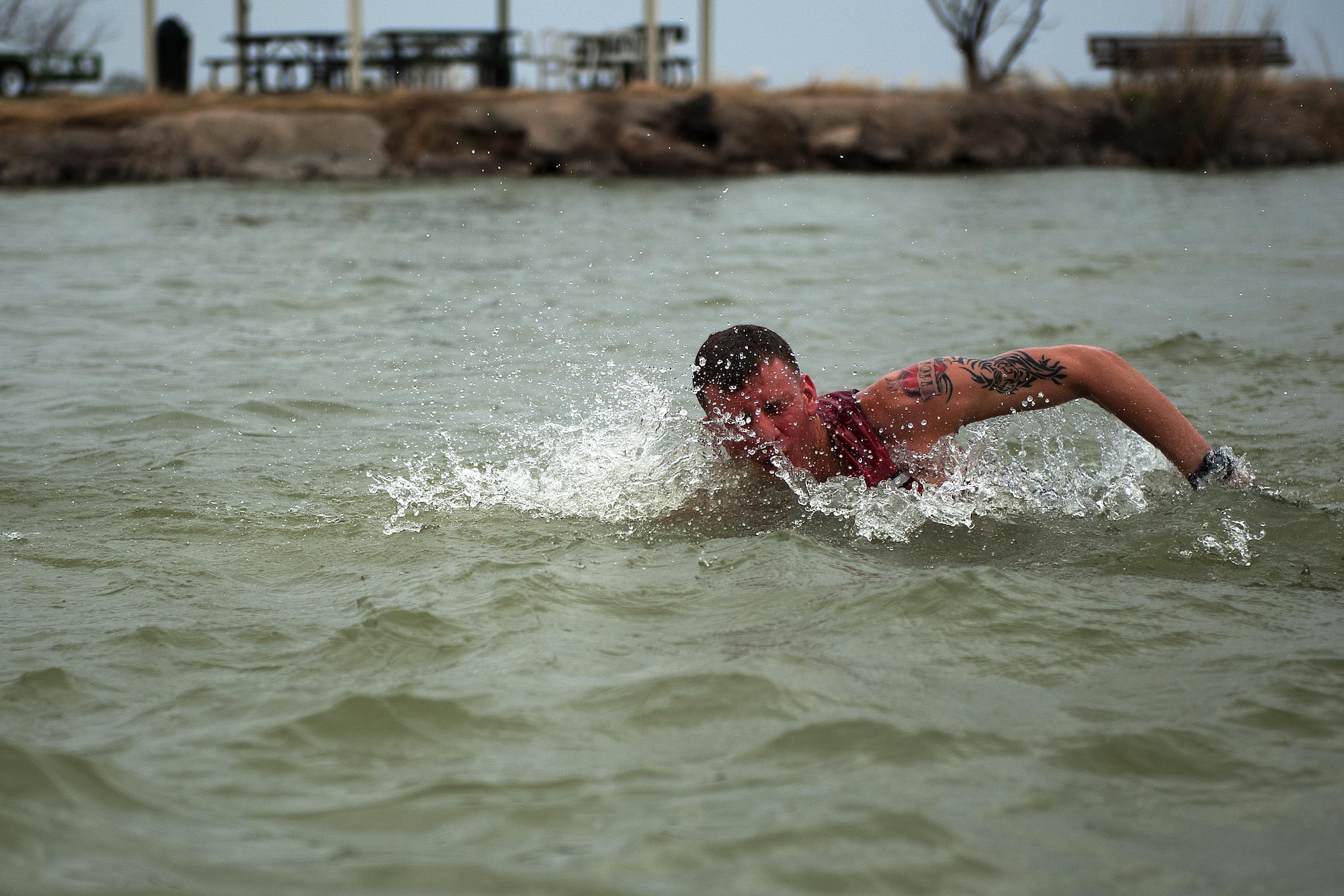 U.S. Air Force Airman 1st Class Kyle M. Carter, 17th Security Forces Squadron entry controller, swims to shore during the Polar Bear Plunge at Goodfellow Recreation Camp, San Angelo, Texas, Feb. 20, 2016. Ice was thrown into the water prior to the plunge as part of tradition. (U.S. Air Force photo by Airman 1st Class Caelynn Ferguson/Released)