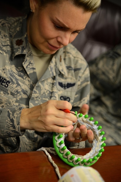 Maj. Connie Jones, 47th Medical Operations Squadron nurse, looms a baby hat at a Heartstrings session on Laughlin Air Force Base, Texas, Jan. 21, 2016. The hand-made knit baby hats made in the Heartstrings “lunch-n-loom” sessions are donated to the Val Verde Regional Medical Center, a local hospital, and local clinics for newborn babies. (U.S. Air Force photo by Senior Airman Ariel D. Partlow)