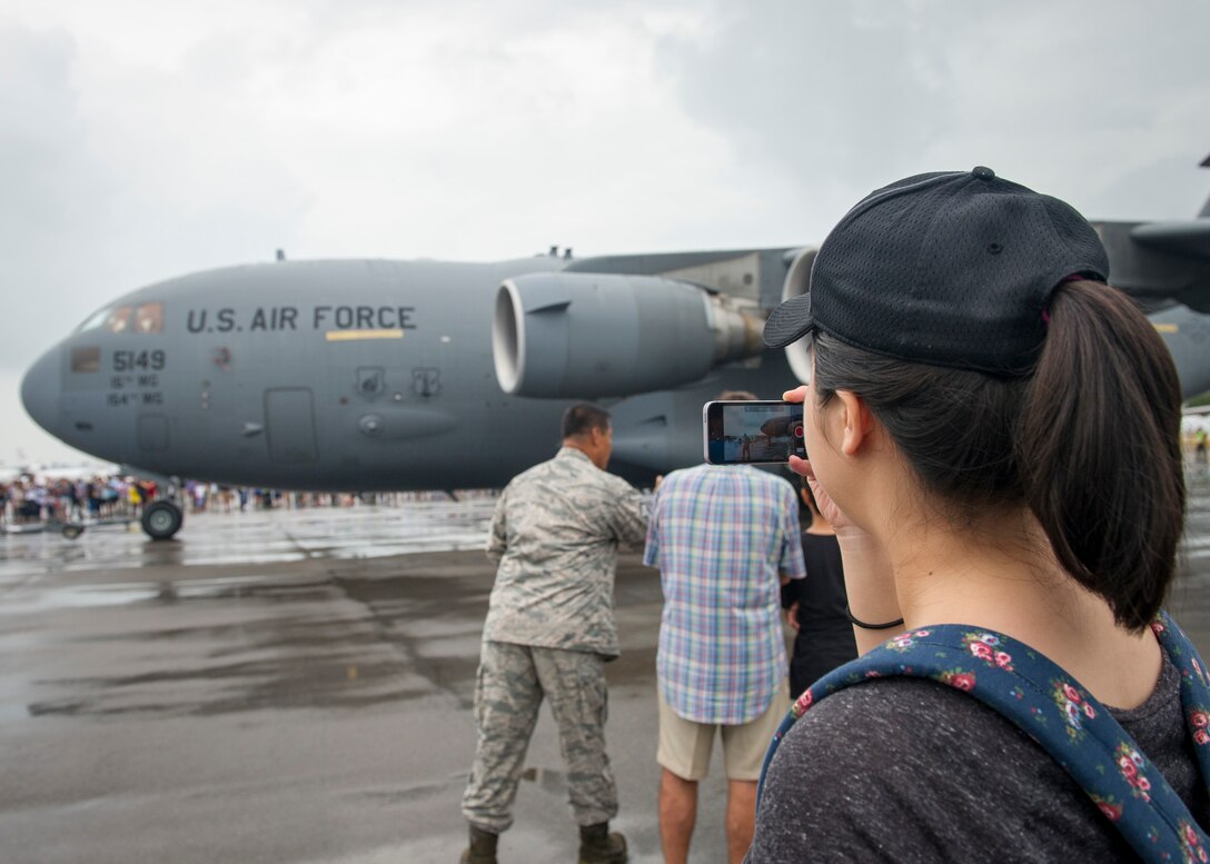 A spectator takes a photo of a U.S. Air Force C-17 Globemaster III during the Singapore International Airshow, at Changi International Airport, Singapore, Feb. 20, 2016. Through participation in airshows and regional events, the U.S. demonstrates its commitment to the security of the Indo-Asia-Pacific region, promotes equipment interoperability, displays the flexible combat capabilities of the U.S. military, and creates lasting relationships with international audiences to strengthen the bonds that support partnership building throughout the Indo-Asia-Pacific region. (U.S. Air Force photo by Capt. Raymond Geoffroy/Released)