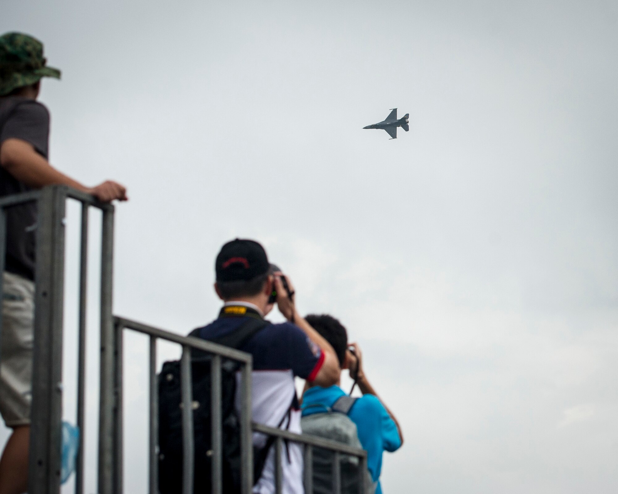 Spectators take pictures as a U.S. Air Force F-16C Fighting Falcon from the 35th Fighter Wing, Misawa Air Base, Japan, performs an aerial demonstration during the Singapore International Airshow, at Changi International Airport, Singapore, Feb. 20, 2016. The show was an opportunity for the U.S. to demonstrate flexible combat capabilities and to deter adversaries, while reassuring allies and partners. (U.S. Air Force photo by Capt. Raymond Geoffroy/Released)