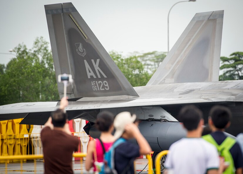 A spectator takes a photo of a U.S. Air Force F-22A Raptor during the Singapore International Airshow, at Changi International Airport, Singapore, Feb. 20, 2016. Throughout the week, U.S. service members showcased a variety of U.S. aircraft. Of particular note, this year marks the first time the Raptor, the U.S. Air Force’s premier 5th generation air dominance fighter, was displayed at the show. (U.S. Air Force photo by Capt. Raymond Geoffroy/Released)