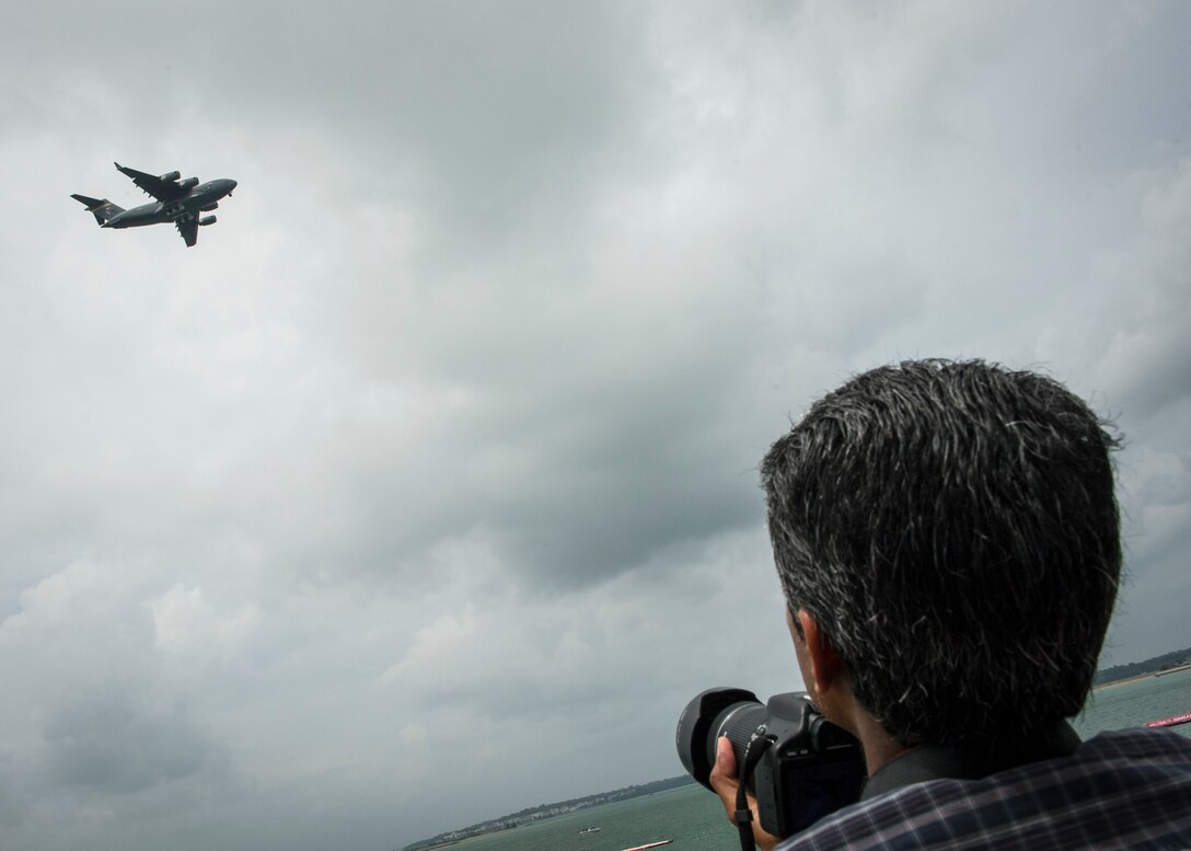 A spectator takes a photo of a U.S. Air Force C-17 Globemaster III during the Singapore International Airshow, at Changi International Airport, Singapore, Feb. 20, 2016. Through participation in airshows and regional events, the U.S. demonstrates its commitment to the security of the Indo-Asia-Pacific region, promotes equipment interoperability, displays the flexible combat capabilities of the U.S. military, and creates lasting relationships with international audiences to strengthen the bonds that support partnership building throughout the Indo-Asia-Pacific region. (U.S. Air Force photo by Capt. Raymond Geoffroy/Released)