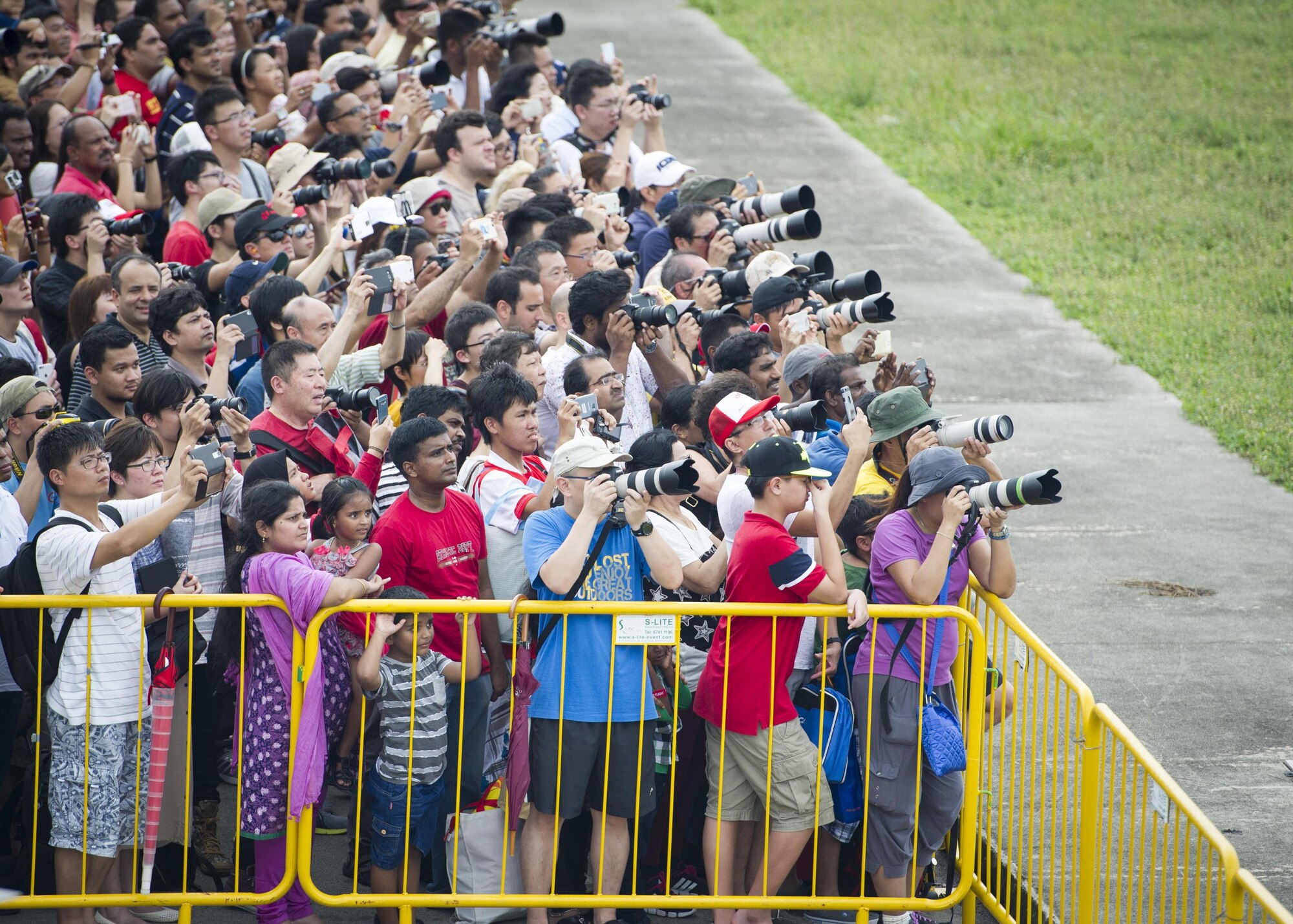 A crowd of spectators watch as a U.S. Air Force C-17 Globemaster III performs an aerial demonstration during the Singapore International Airshow, at Changi International Airport, Singapore, Feb. 20, 2016. The show is focused on building strong relations between Singapore, U.S. and the international community. (U.S. Air Force photo by Capt. Raymond Geoffroy/Released)